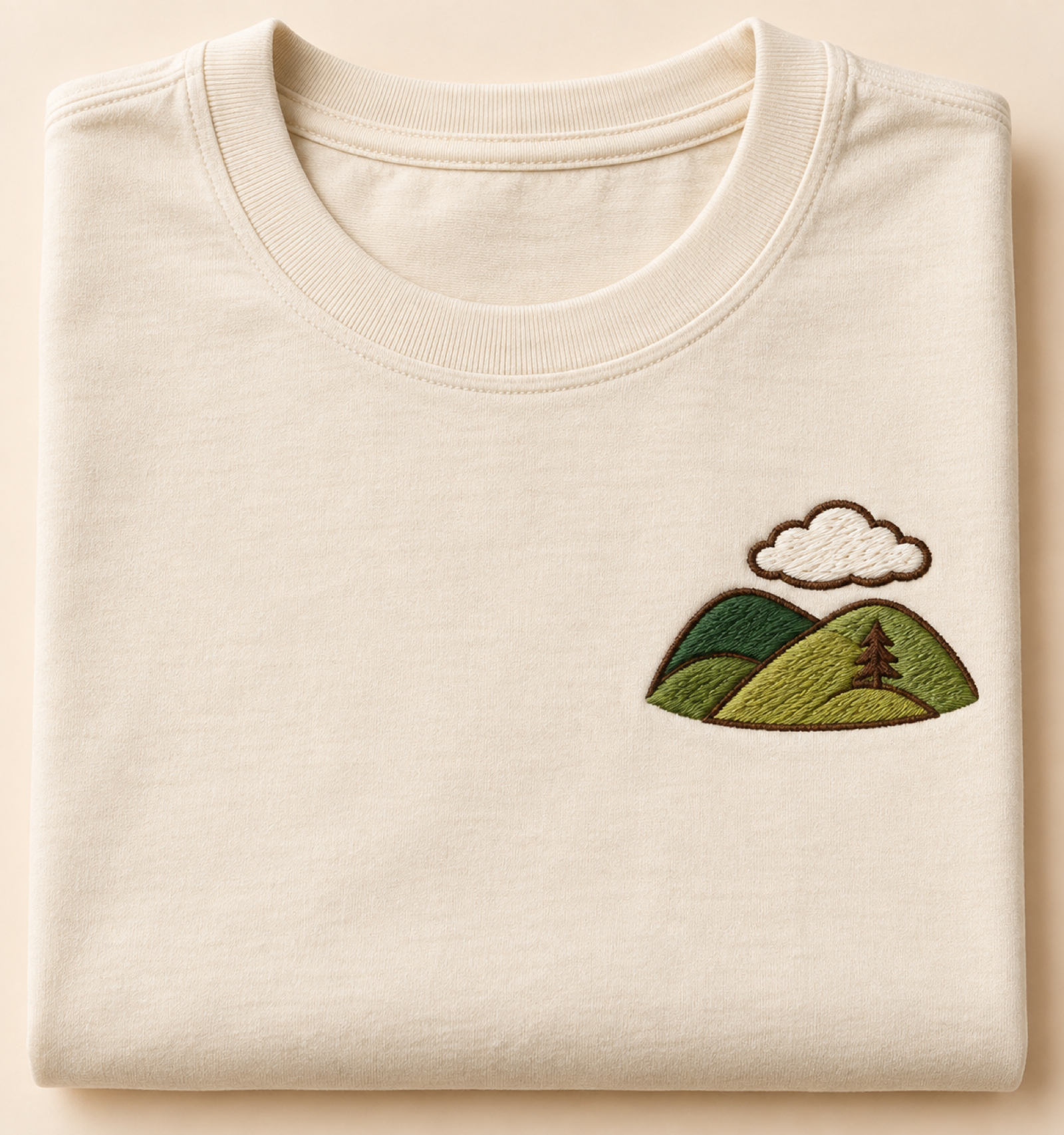 Machine-embroidered green hills and cloud motif on a t-shirt, Meghalaya